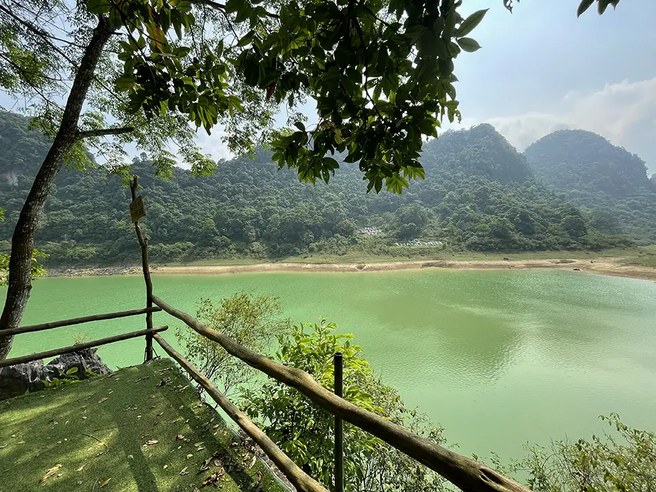 Thang Hen Lake in Cao Bang with emerald water and limestone peaks under mild winter skies in northern Vietnam.