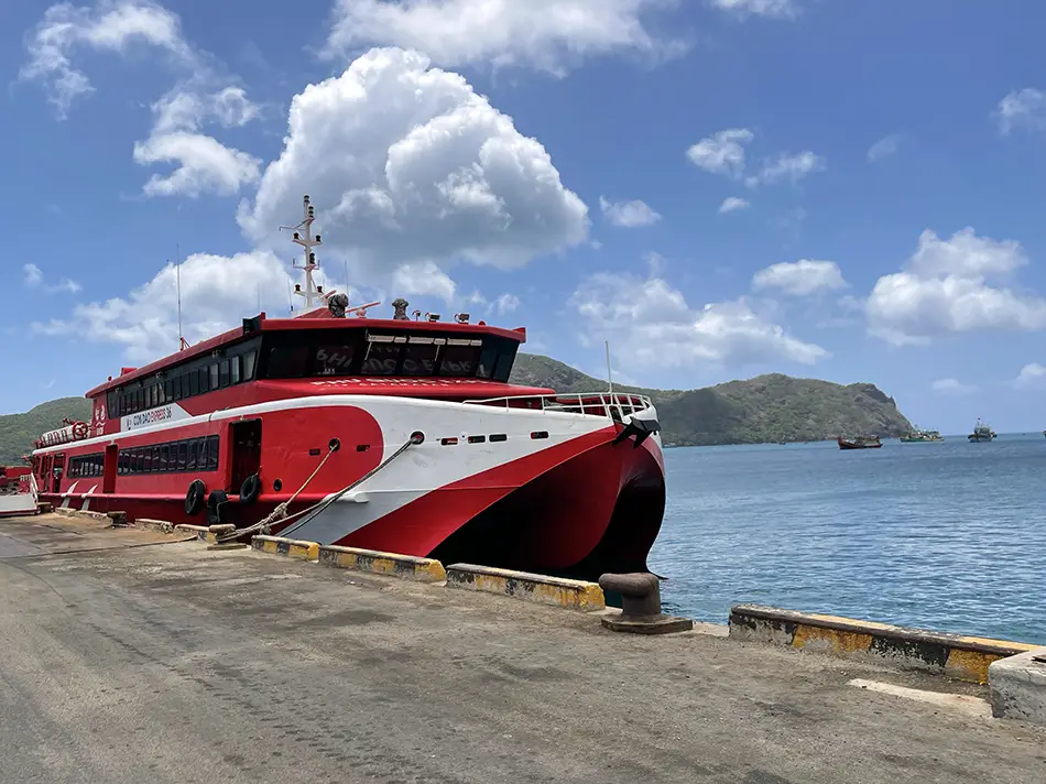 Red high-speed ferry docked at a pier in Con Dao, Vietnam, used by travelers to reach the island from the mainland