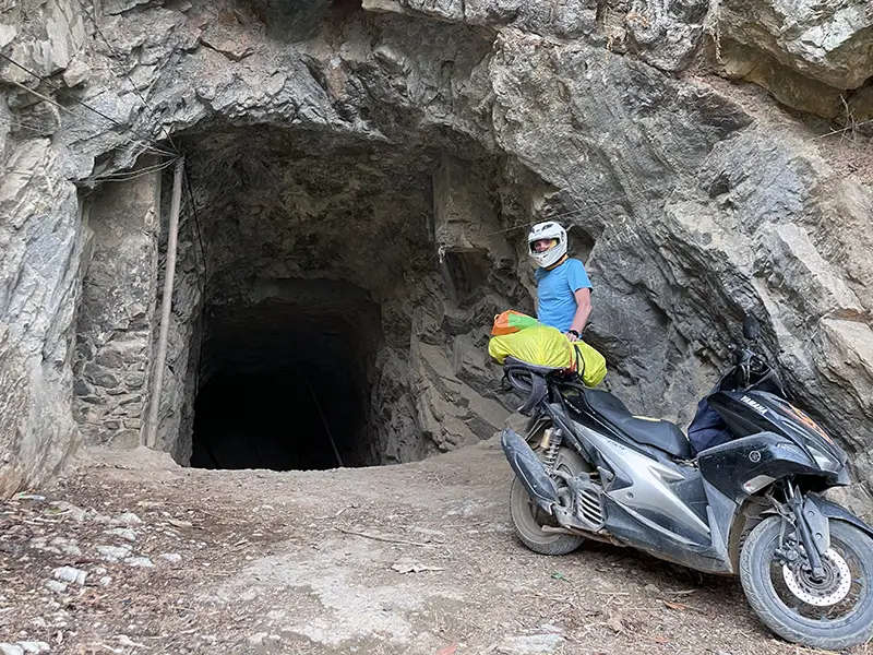 Travelers motorbike parked at Ban Tham Cave, where riders can drive through the natural limestone tunnel.