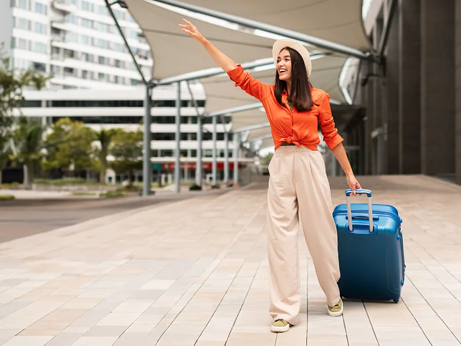 Woman with luggage waiting for airport transfer, illustrating how to get around Vietnam right after arrival.