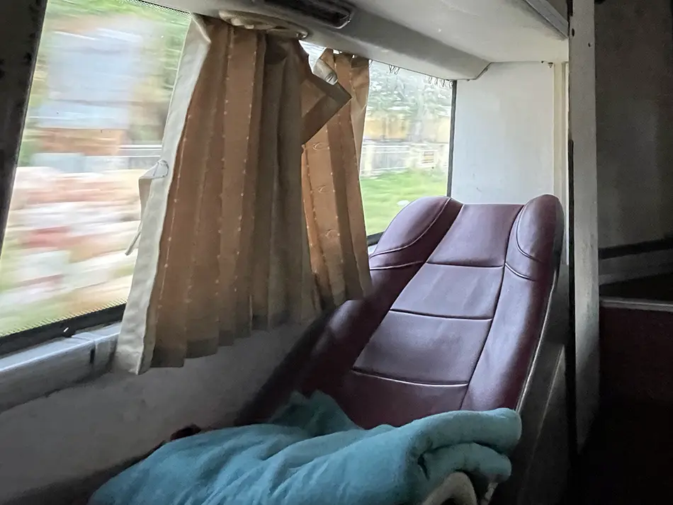 Budget sleeper bus seat setup commonly used by backpackers traveling long distances across Vietnam overnight.