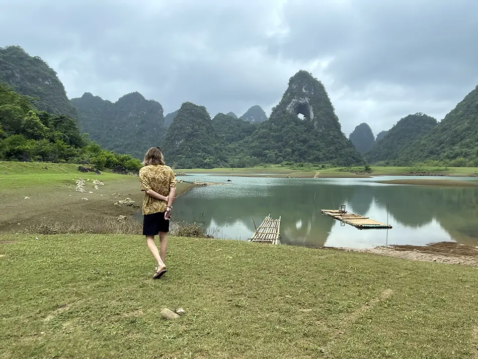 Traveler gazing at a mountain-ringed lake in Cao Bang, a peaceful off-grid destination in northern Vietnam’s karst landscape