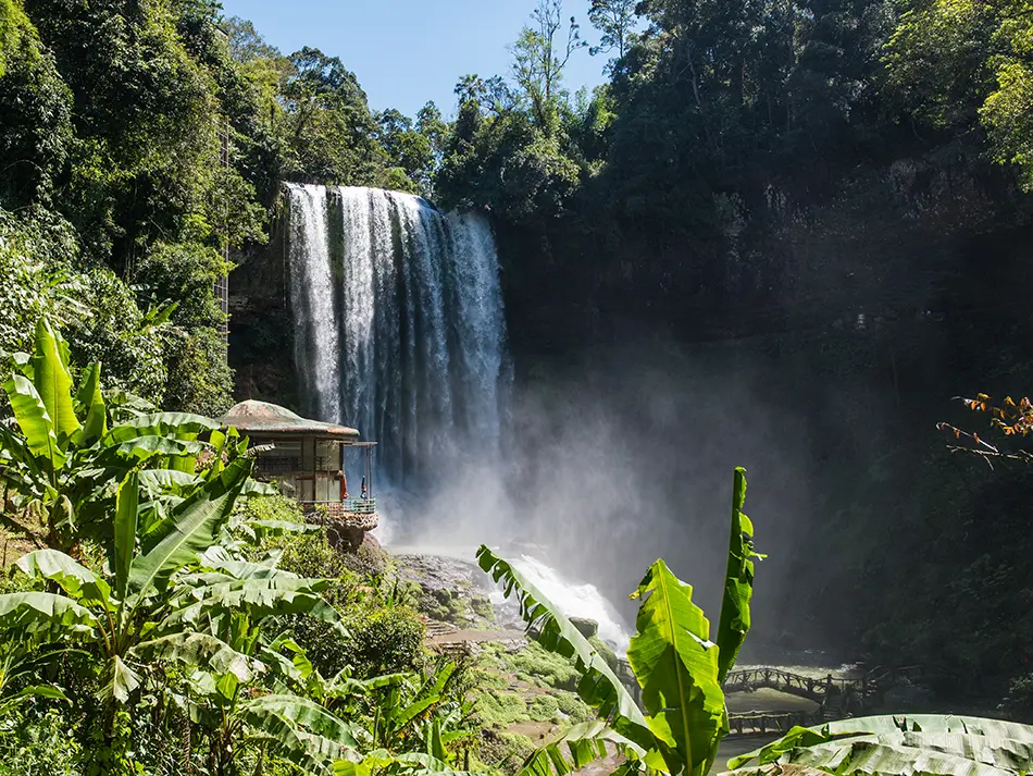 Dambri Waterfall cascading beside a small temple in the forest near Bao Loc, Vietnam’s Central Highlands