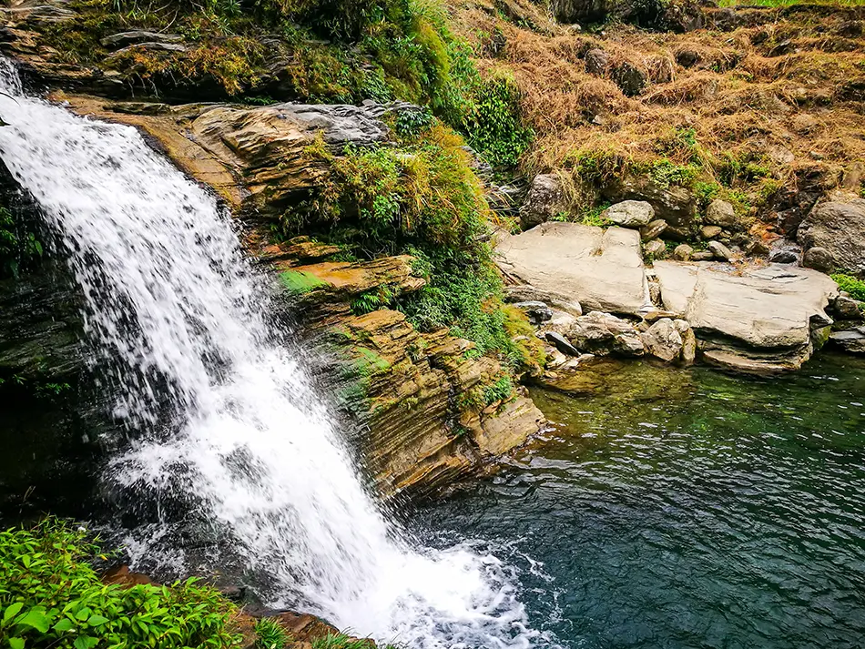 Du Gia Waterfall spilling into a clear natural pool, a peaceful stop along the Ha Giang motorbike loop