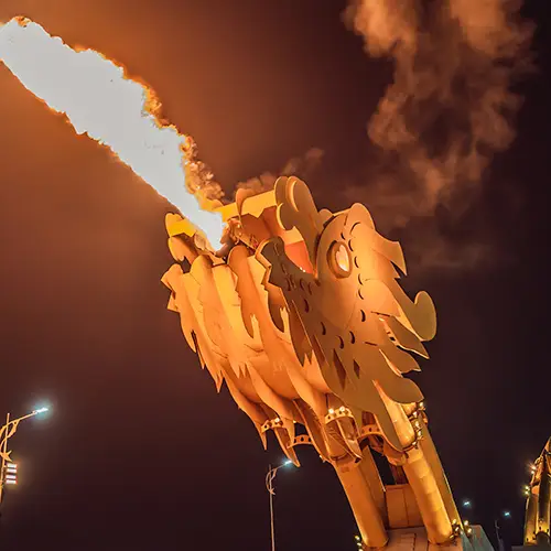 Fire show at Da Nang's Dragon Bridge during weekend night performance, with flames erupting from the dragon's mouth