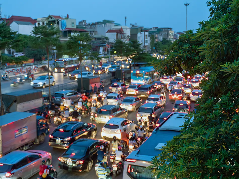 Dense traffic of cars and motorbikes during rush hour in Hanoi highlights real-life Vietnam transportation options.