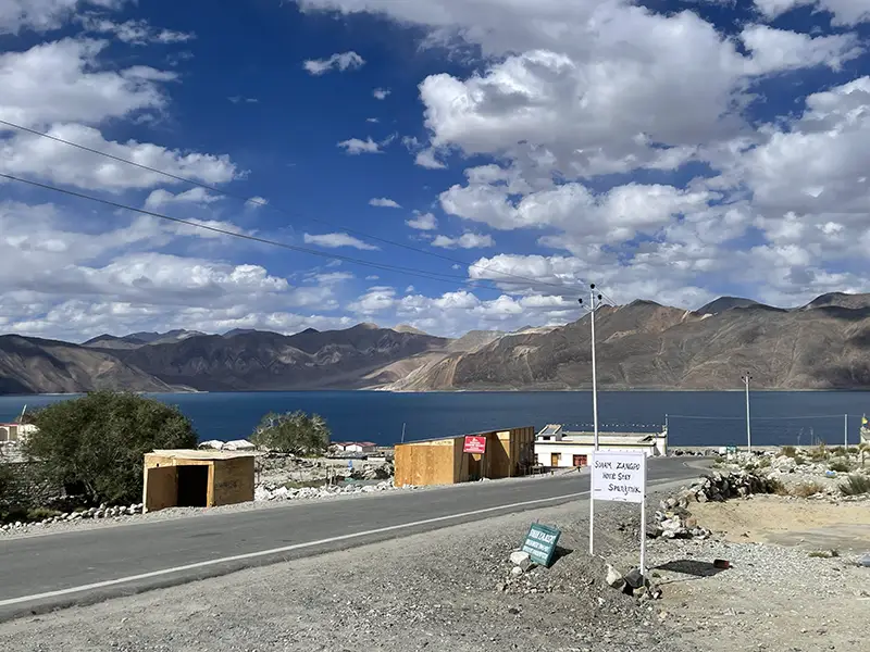 Pangong Lake under Himalayan summer skies with mountain ridges in the background