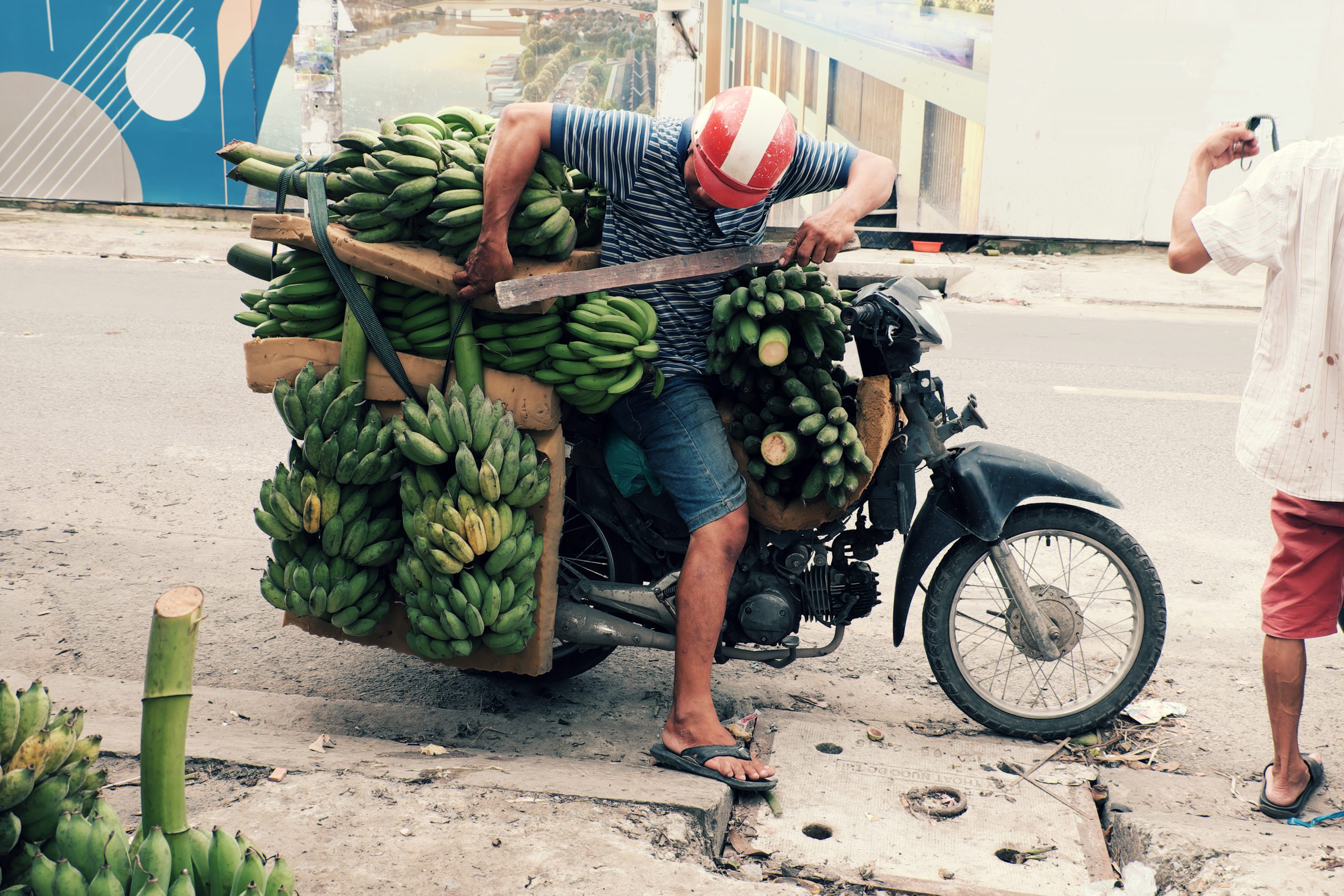 Heavily loaded motorbike carrying bananas, showcasing how Vietnam transportation options include versatile local delivery methods.