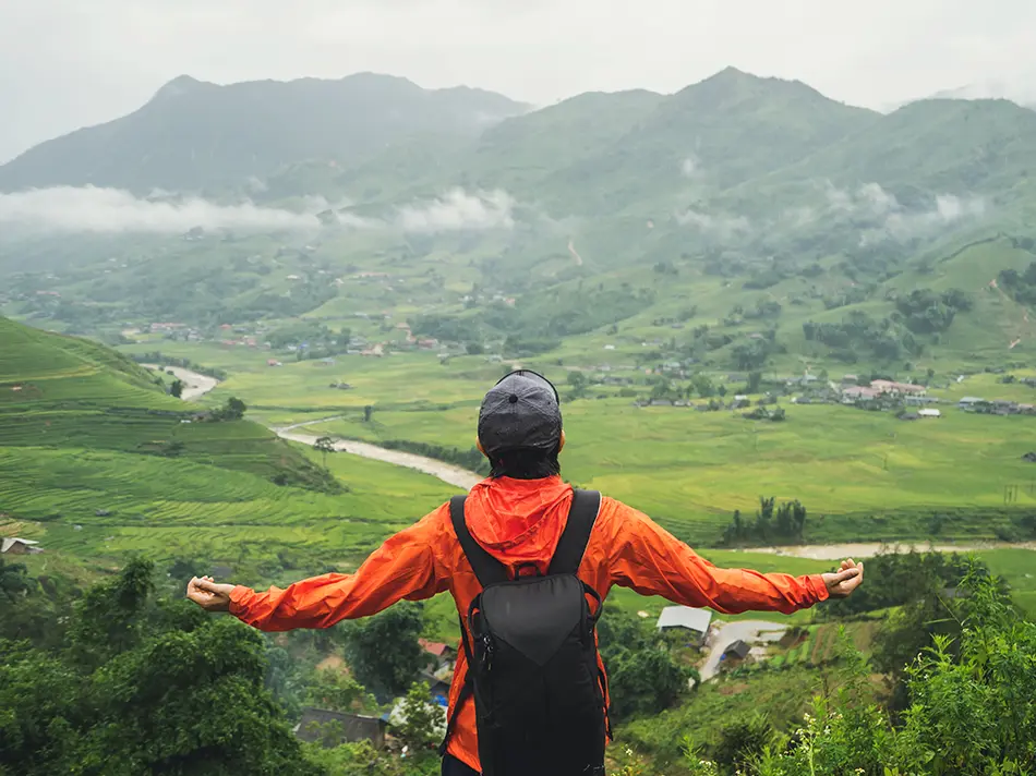 Backpacker overlooks misty rice fields in Sapa, a scenic off the beaten path destination in Northern Vietnam