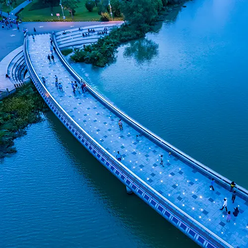 Aerial view of Starlight Bridge in Ho Chi Minh City during daytime with blue-toned pedestrian path over a calm lake