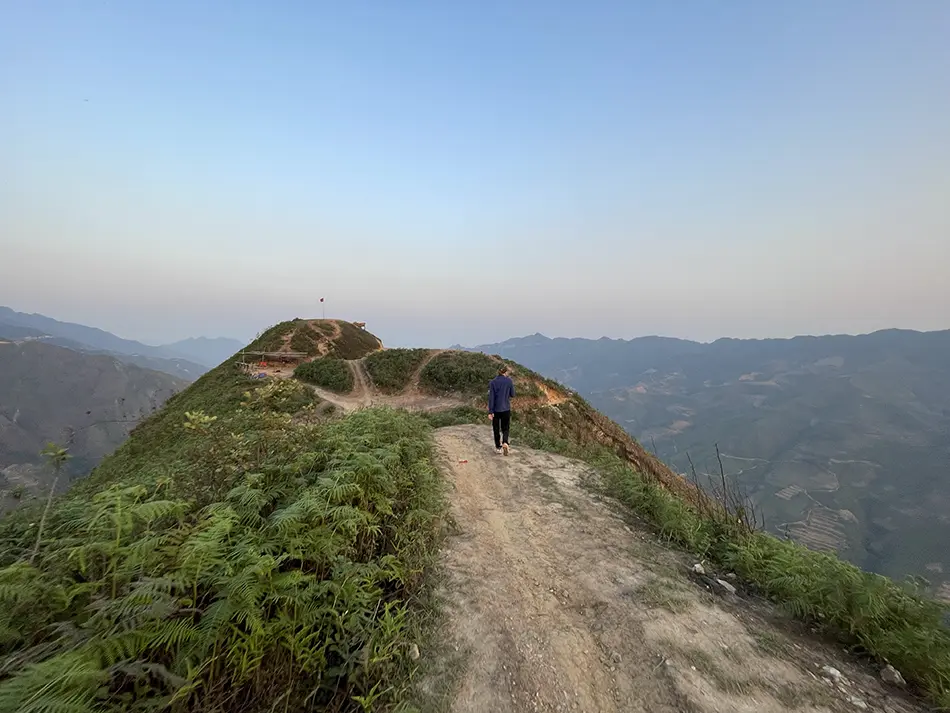 Hiker on the Dinosaur Spine trail in Ta Xua, a rugged ridgeline hike known for cloud hunting and remote mountain views