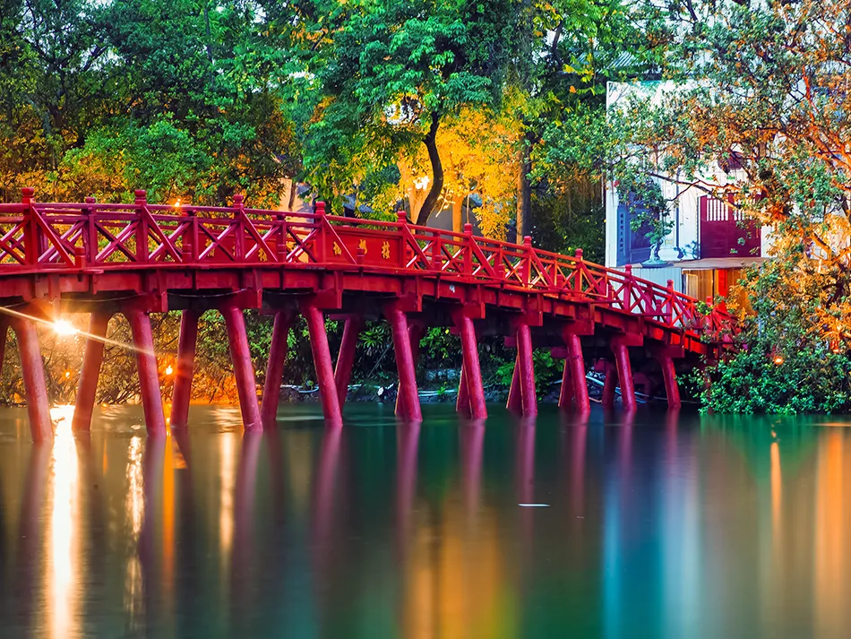 Bright photo of The Huc Bridge in Hanoi leading to a small temple on the island