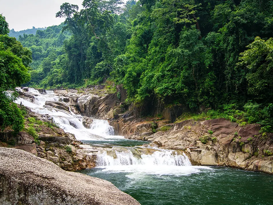 Yang Bay Waterfall flowing over smooth rock steps in the jungle near Nha Trang, a hidden nature spot in Vietnam