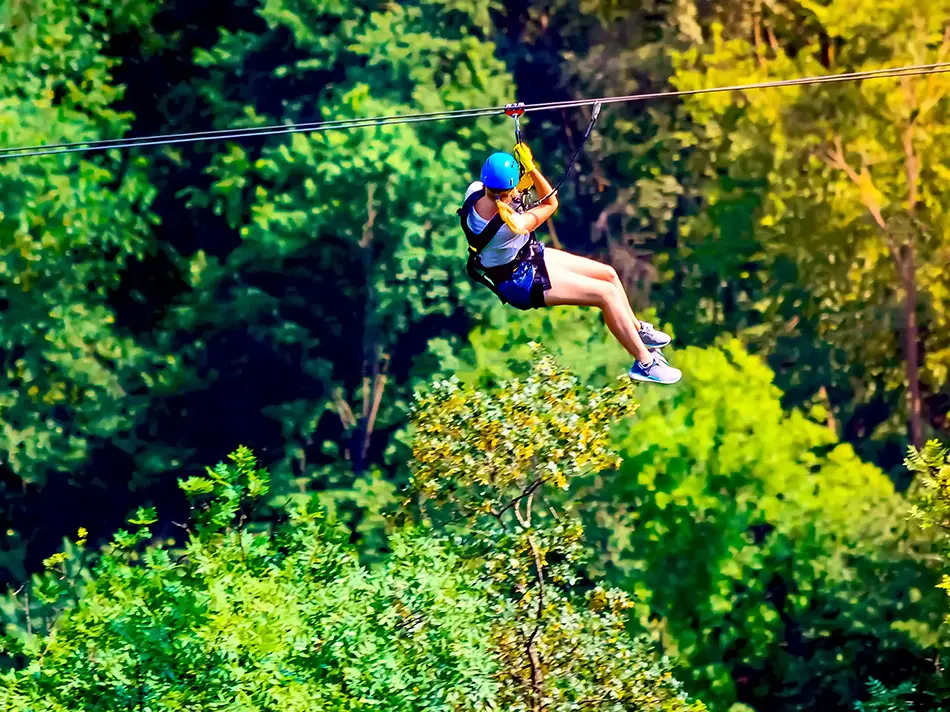 Traveler ziplining through forest in Armenia