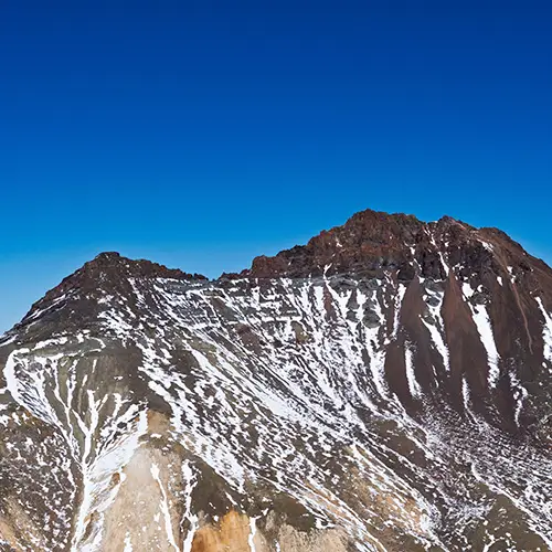 Snow-covered summit of Mount Aragats, seen from Byurakan, a top destination for mountain hikes in Armenia