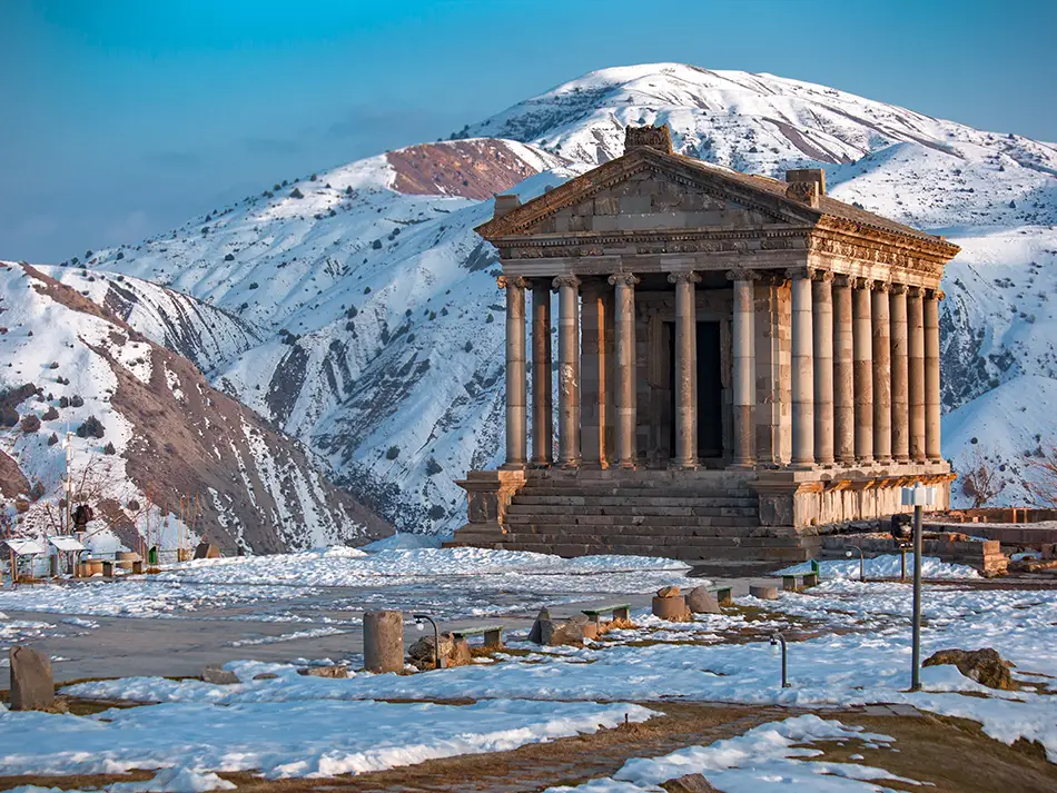 Pagan Temple of Garni surrounded by snow-capped mountains, a rare Greco-Roman site in Armenia