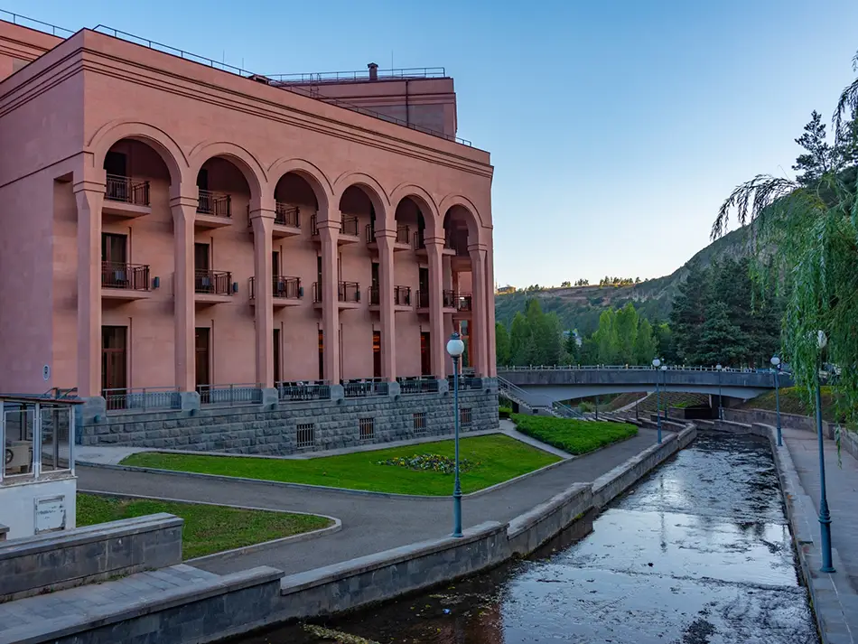 Historic sanatorium building beside river in Jermuk, a popular wellness destination in Armenia