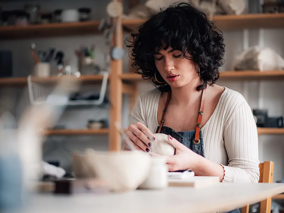 A woman participating in a traditional Armenian pottery masterclass, a hands-on cultural experience for travelers