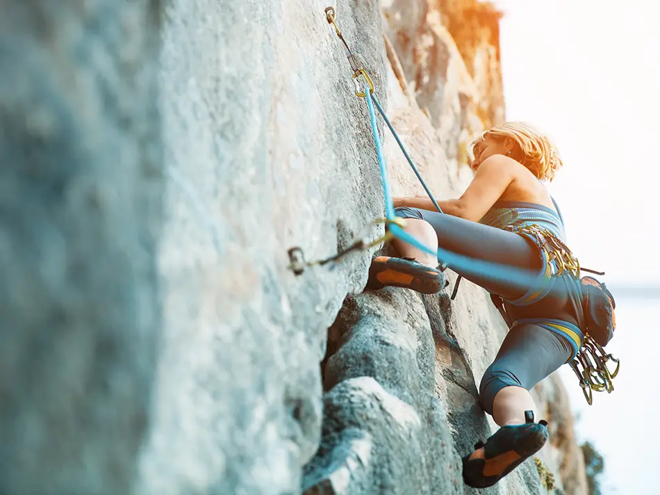 Female traveler rock climbing in Armenia’s mountainous terrain, a top outdoor adventure experience