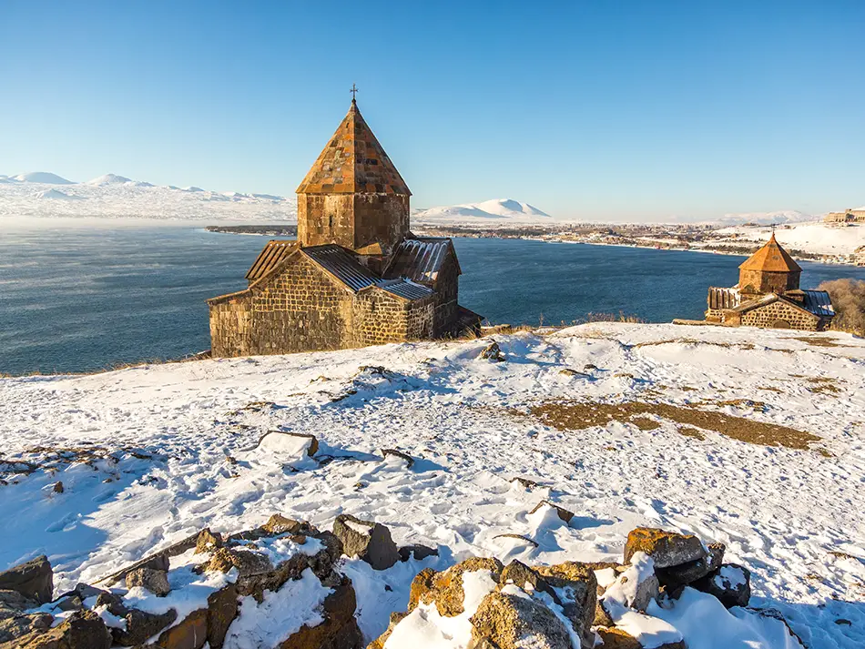 Best time to visit Sevan hinted by a snowy lakeside church and clear skies.