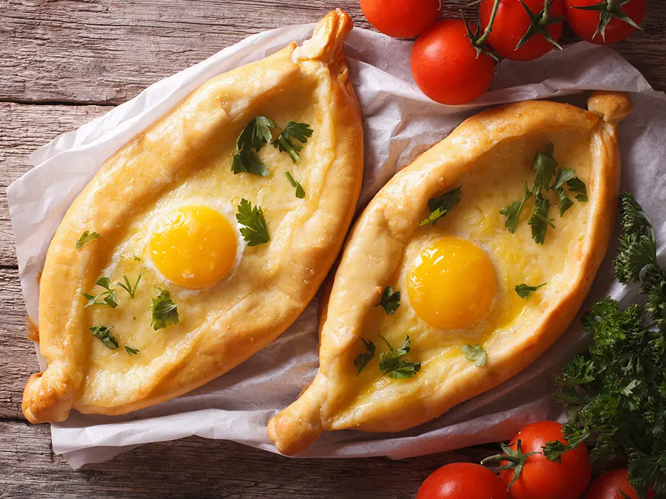 Iconic dish Georgia: adjaria khachapuri with melted cheese and a bright egg yolk.