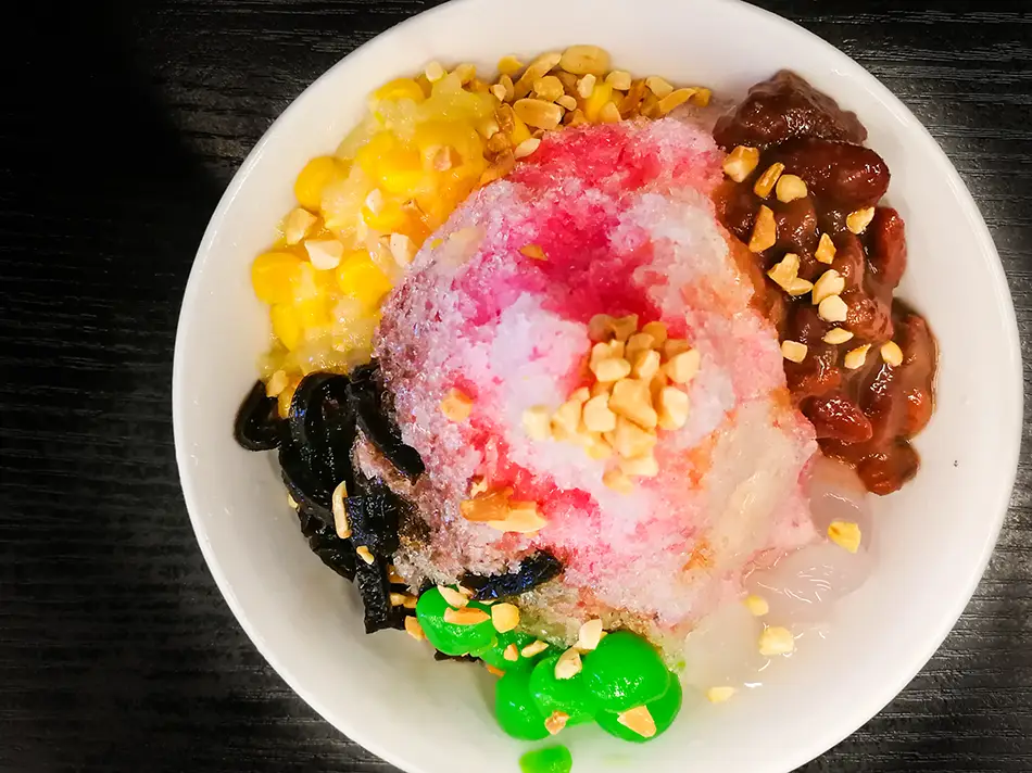 Colorful ais kacang topped with beans, corn and syrups, a famous Malaysian dessert.