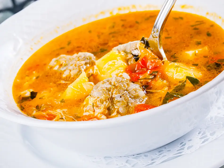 Kololik meatball soup with herbs and vegetables, representing comforting homemade Armenian food