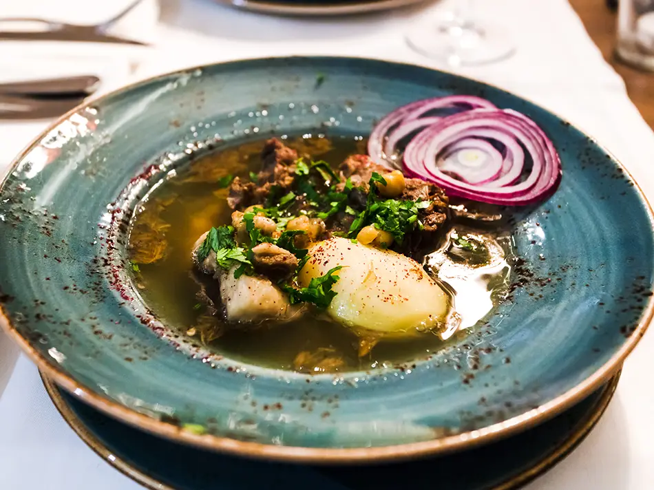 Hearty Armenian putuk soup served in a ceramic pot, a regional specialty made with chickpeas and lamb.