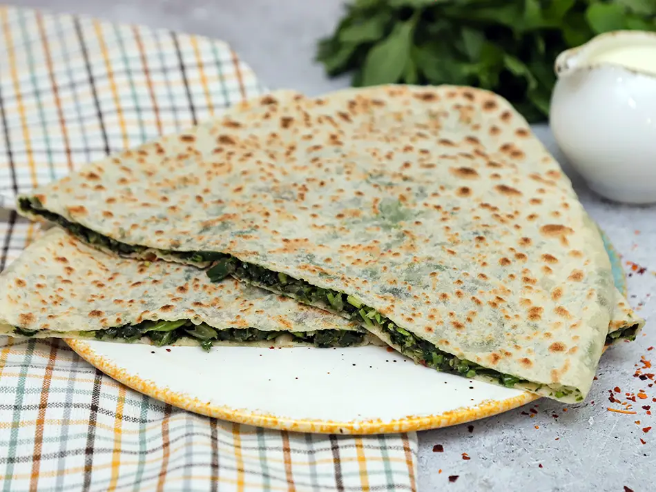 Flatbread stuffed with wild herbs, known as zhingyalov hats, a unique and healthy Armenian street food.