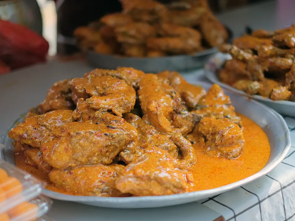 Grilled ayam percik basted in spiced coconut sauce, one of the famous Malaysian foods.
