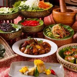 A vibrant display of the best food in Cambodia, featuring classic dishes like amok trey, khor sach chrouk, bok l’hong papaya salad, seafood, and traditional Cambodian desserts on a festive table setting