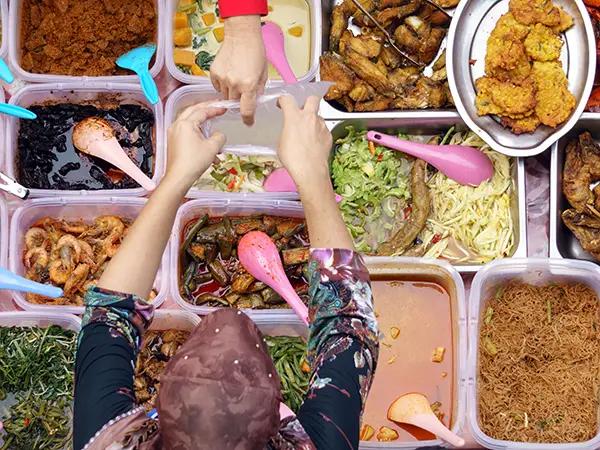 Overhead flat lay of Malaysia dishes: fried chicken, stir-fried noodles, spicy prawn curry
