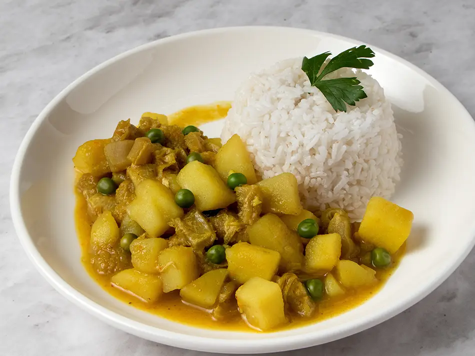 Iconic foods of Peru: cau cau tripe and potatoes in golden aji amarillo sauce, Lima.