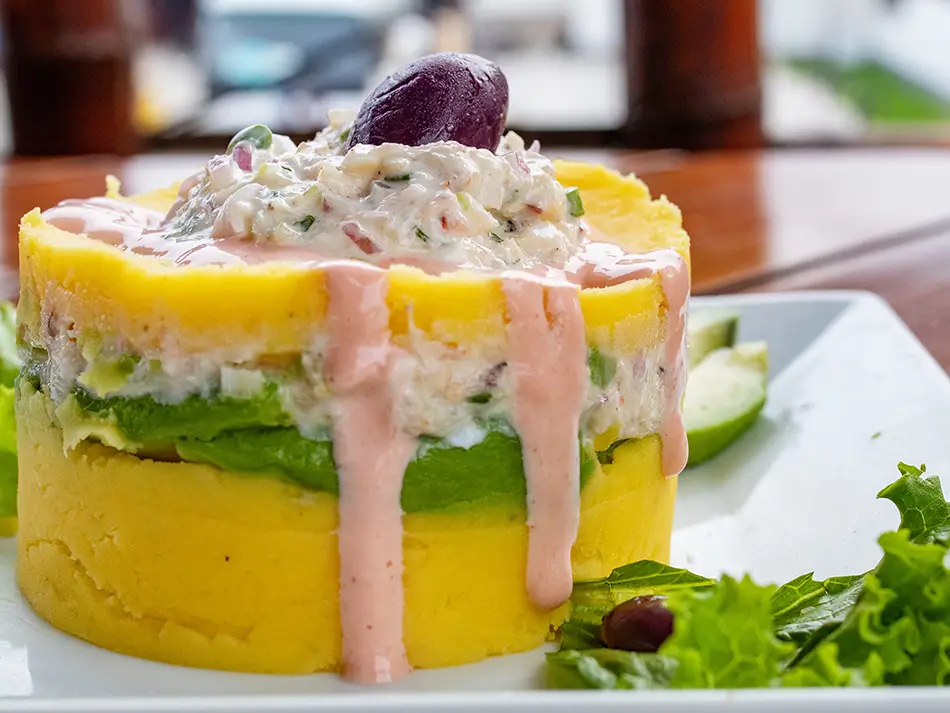 Best dishes in Peru: causa rellena layered potato with tuna and avocado, served chilled in Lima.
