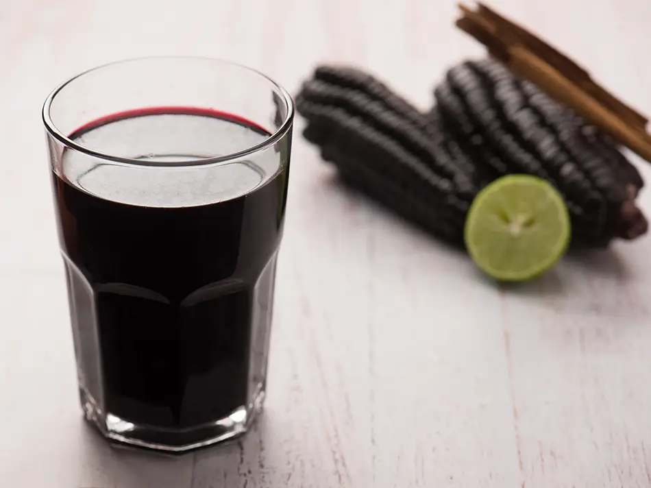 A tall glass of chicha morada with ice in Lima.