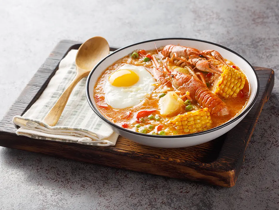 Creamy shrimp chowder with potatoes, corn and poached egg in Arequipa — best food in Peru.