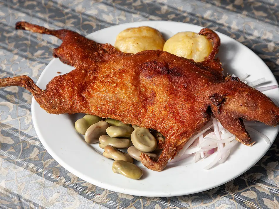 Must-try foods in Peru: cuy chactado flattened and crispy, plated with potatoes in Arequipa.