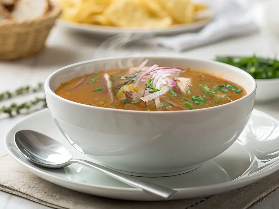 Tuna and yuca soup topped with pickled red onions in Guayaquil.