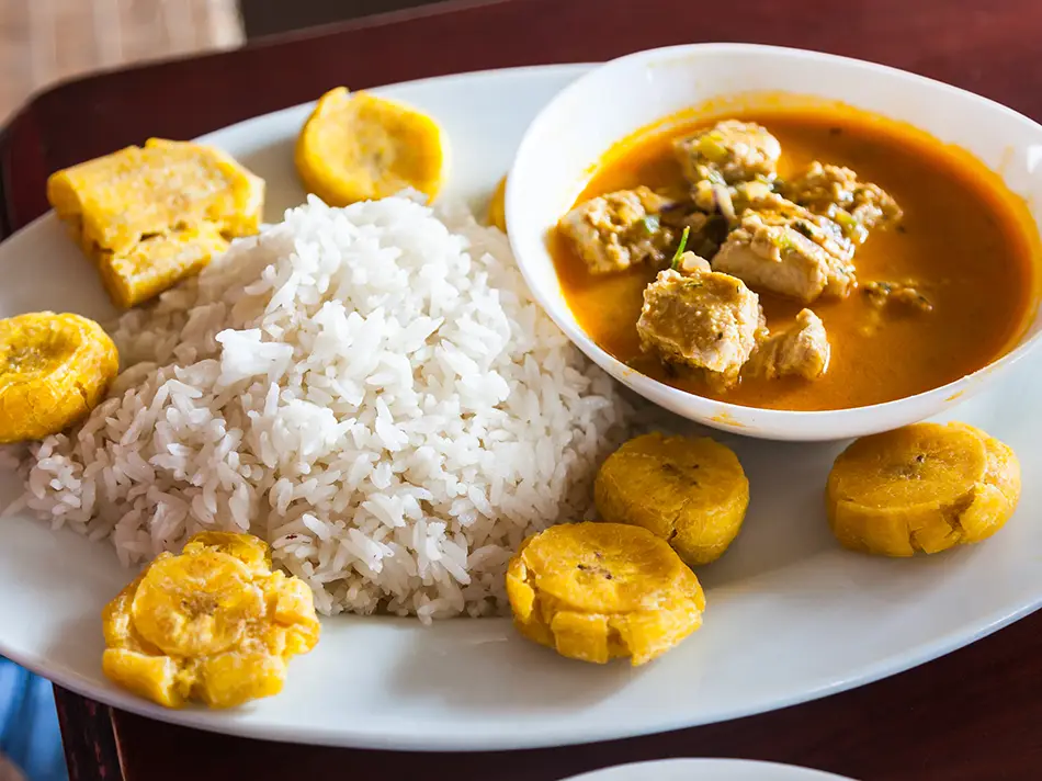Best food in Ecuador showcases encocado de pescado, fish in coconut sauce with peppers and herbs.