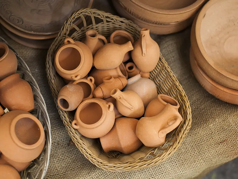 Handmade clay pots and pitchers arranged on a tray from a local Gyumri workshop.