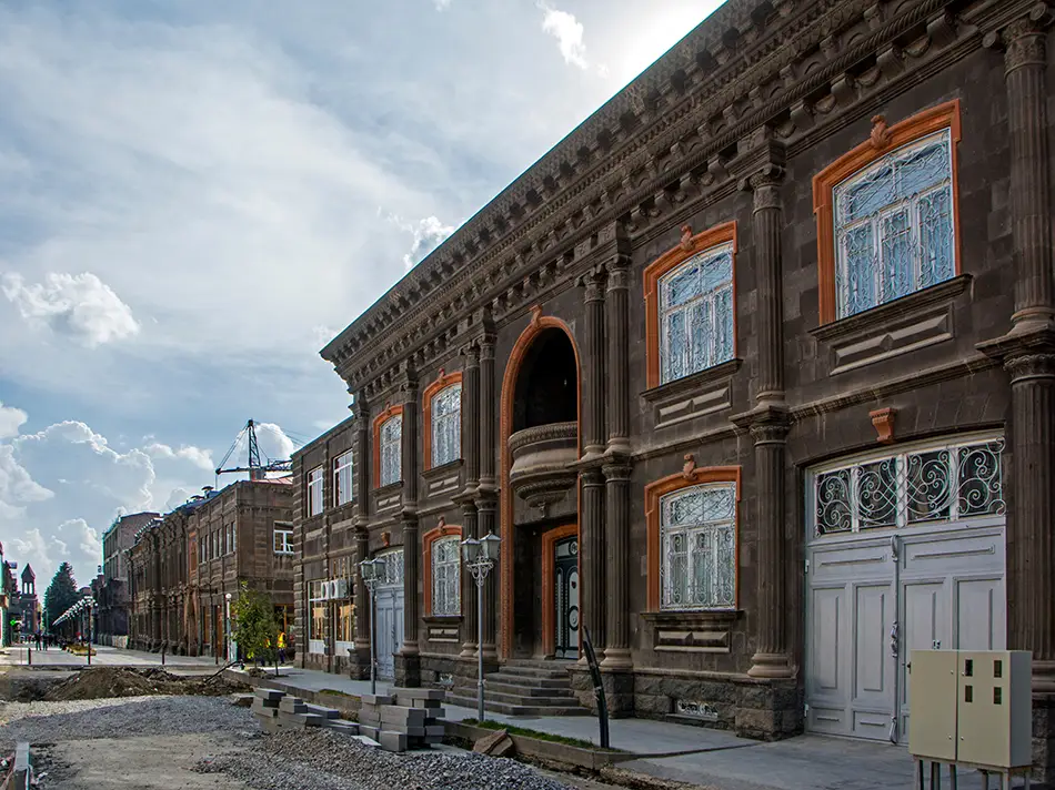 Sunlit historic street with brick facades hints at best time to visit Gyumri.