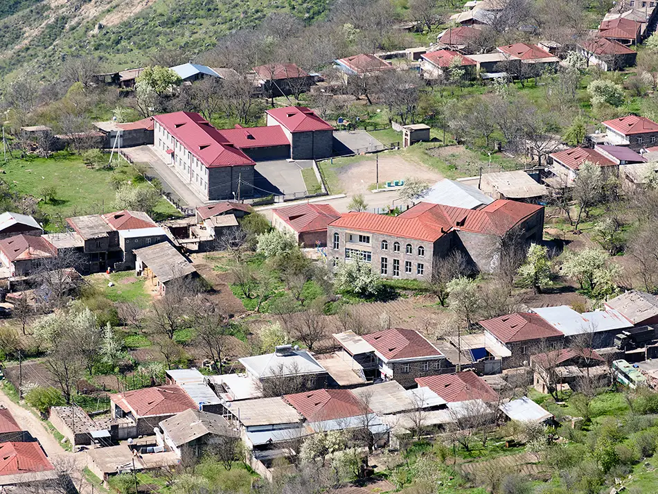 Cluster of traditional stone houses in Halidzor village nestled among springtime greenery.
