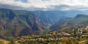 Aerial panorama of Halidzor village surrounded by deep green mountains and the Vorotan Gorge.