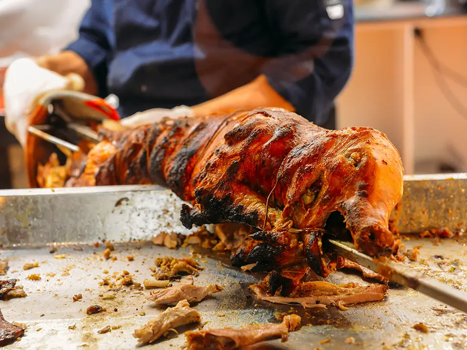 Market platter of hornado with crackling cuero and mote, part of Best food in Ecuador, with salad.