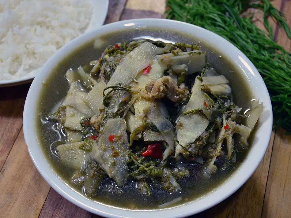 Herbal kaeng nor mai bamboo shoot stew with yanang greens and mushrooms, traditional Lao dishes.