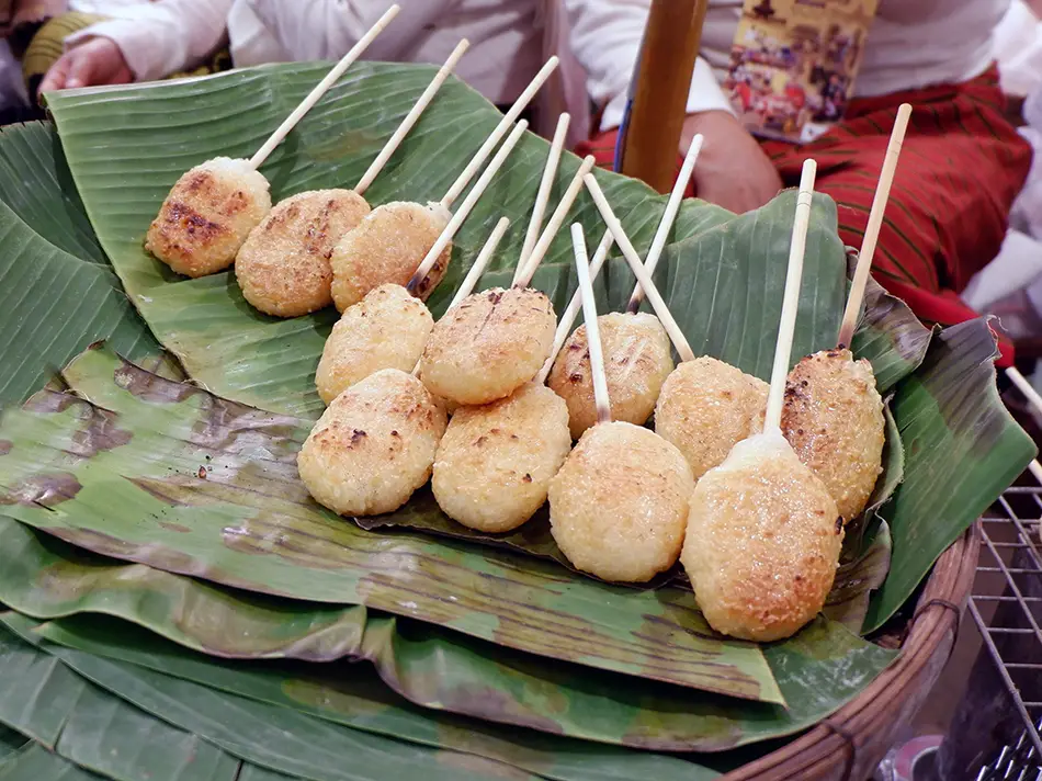 Grilled sticky-rice patty brushed with egg over charcoal, local food in Laos street snack.