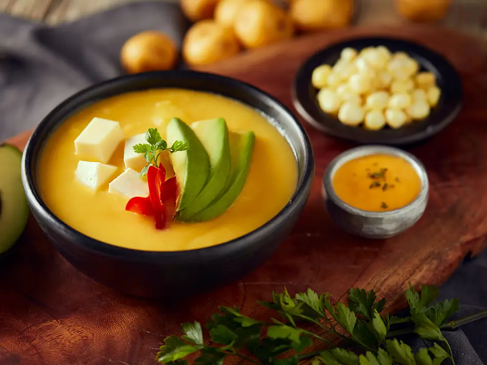 Creamy locro de papa with queso and avocado slices.