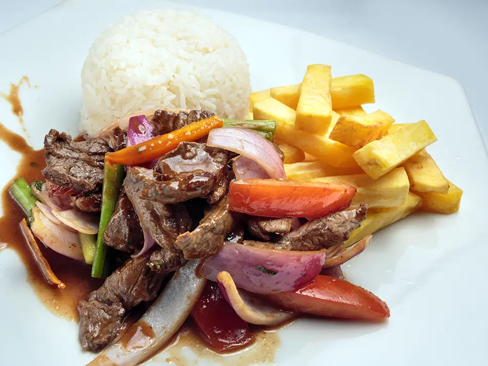 Wok-seared beef with onions, tomatoes and fries in Lima — best food in Peru.
