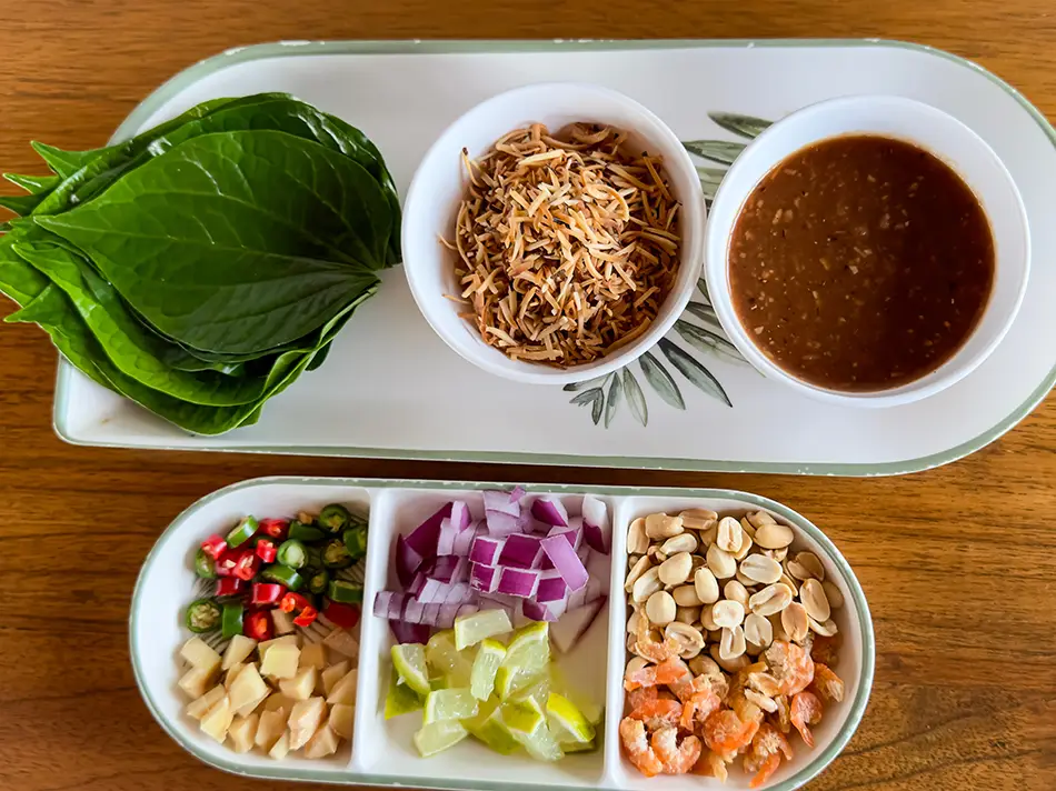 Miang leaf wraps filled with ginger, peanuts, chilies and lime — traditional Lao dishes.
