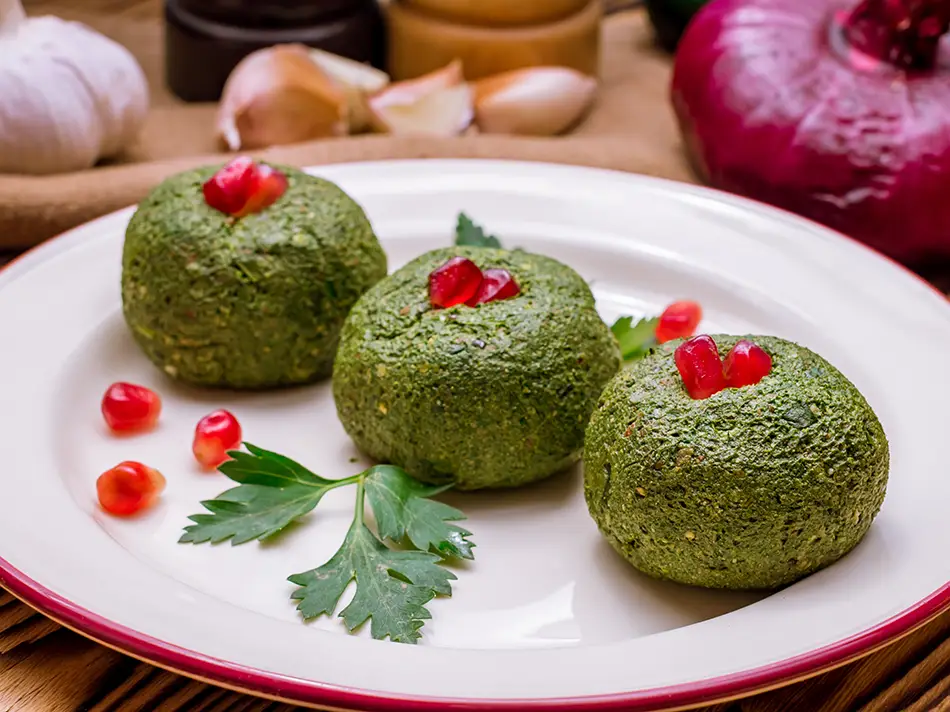 Famous Georgia foods: pkhali spinach patties with walnut paste and pomegranate seeds.